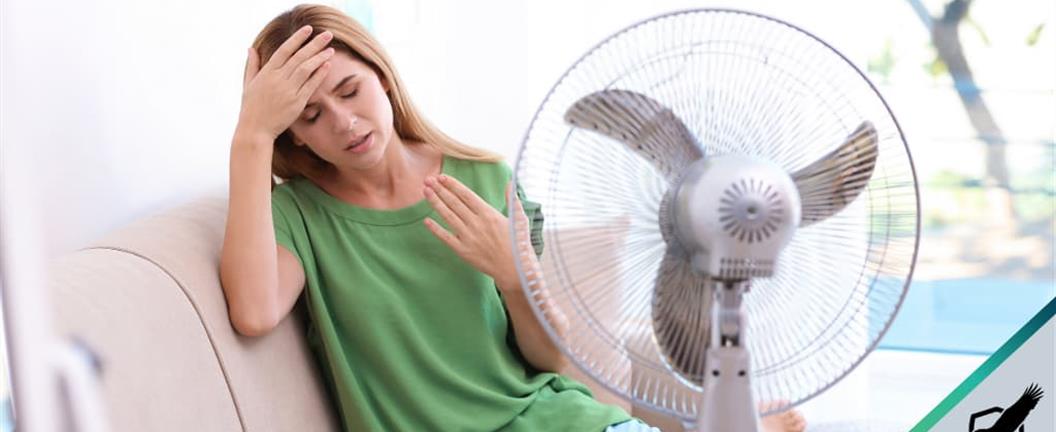 Lady using fan on a very hot day
