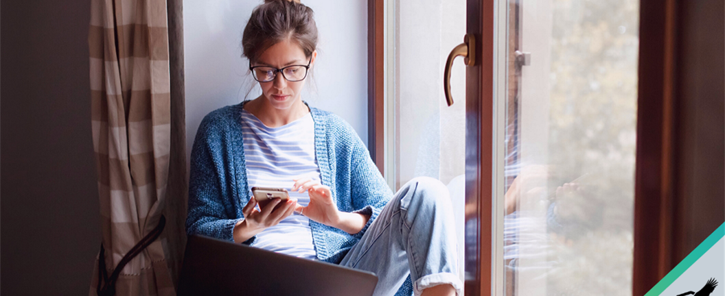 Lady using phone and laptop in her home