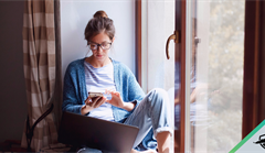 Lady using phone and laptop in her home
