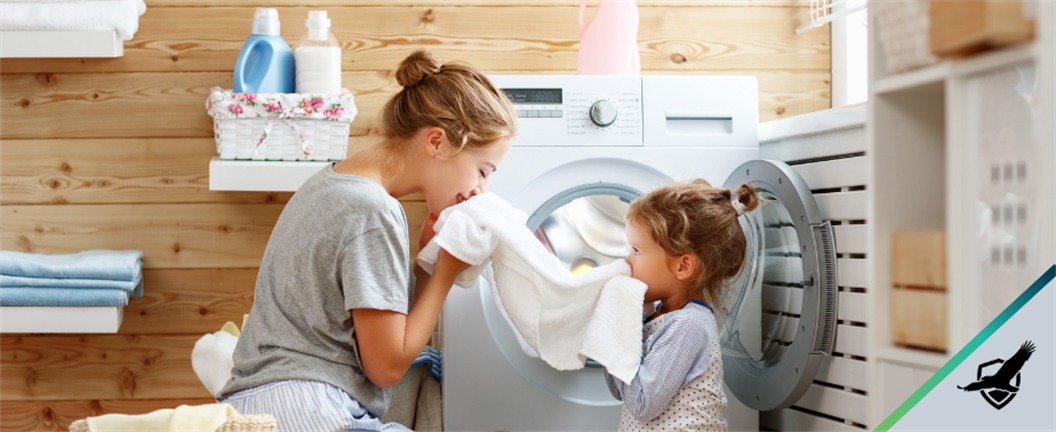 Mother  and young daughter smelling fresh laundry