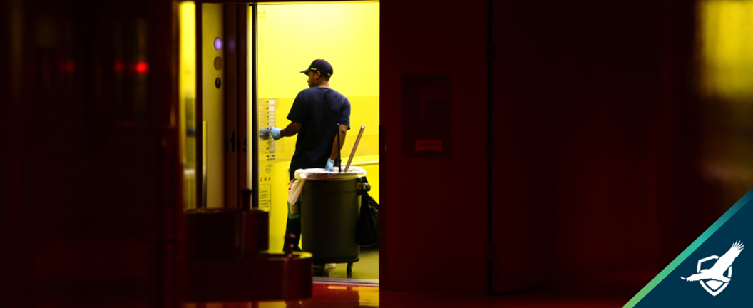 Janitor walking into elevtor with trash bin