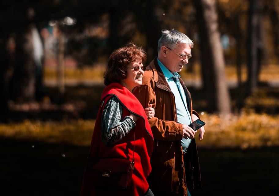 Senior couple walking through park